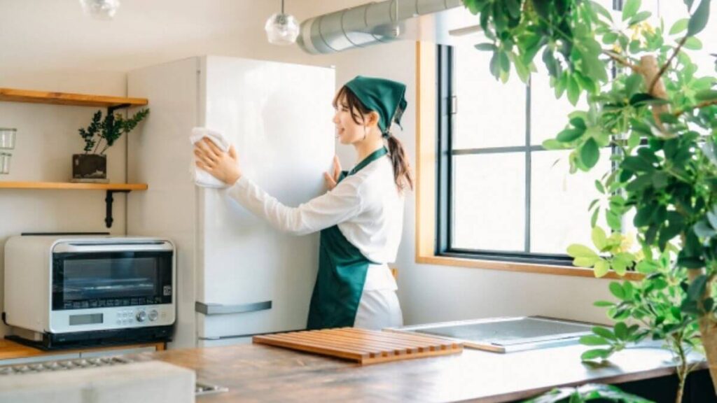 冷蔵庫を掃除するクリーニング業者の女性