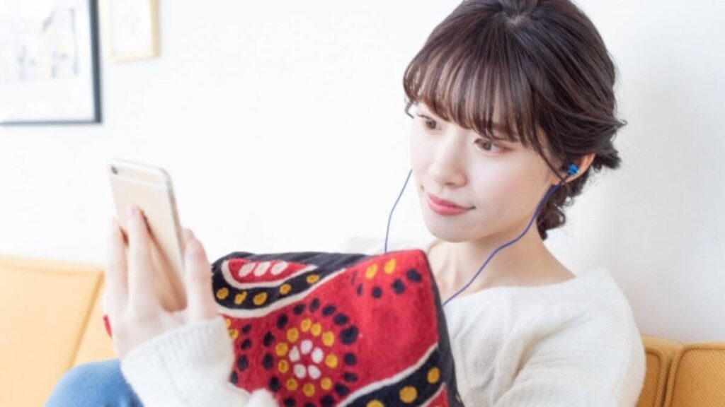 イヤホンで音楽を聴きながらリラックスする女性