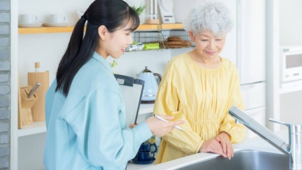 クリーニング業者から説明を受ける高齢女性
