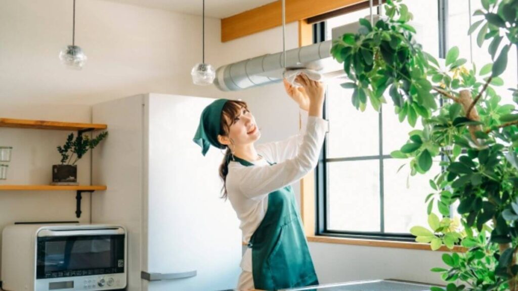 キッチンを掃除するハウスクリーニング業者の女性
