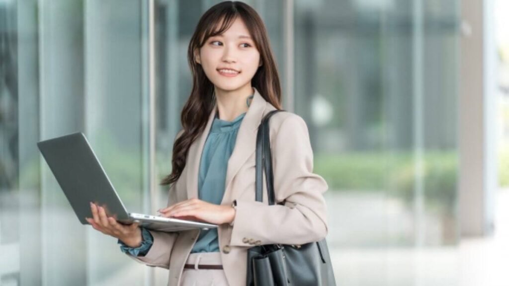 パソコンを持ち仕事をするスーツ姿の女性