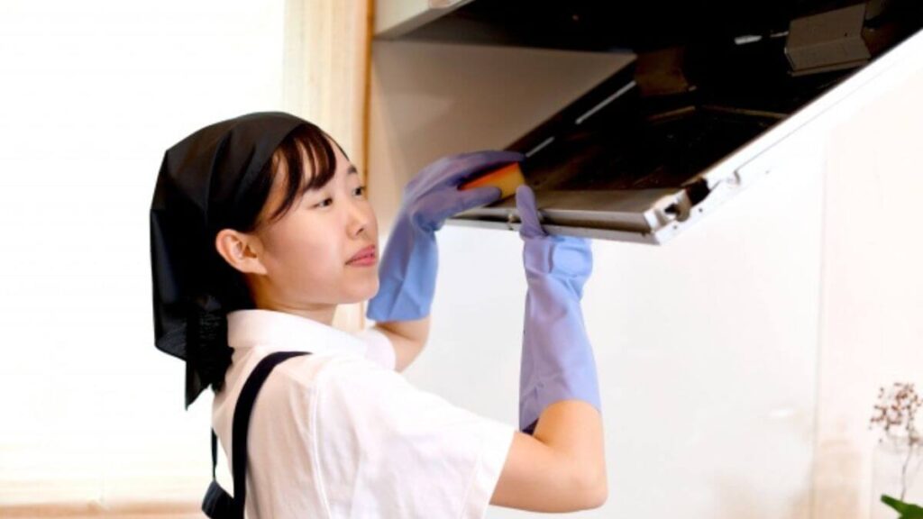 換気扇を掃除するクリーニング業者の女性