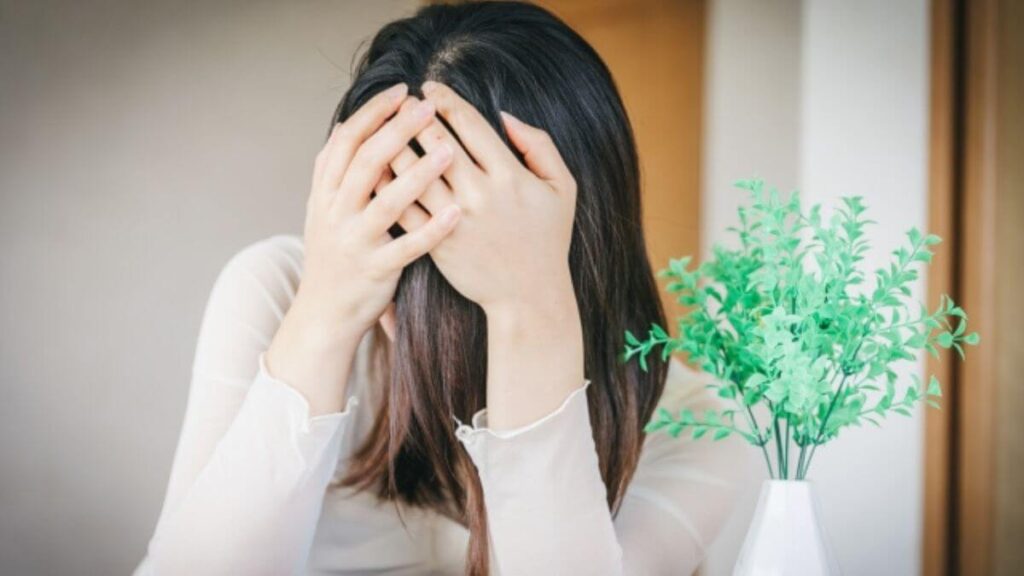 リビングで頭を抱える若い女性