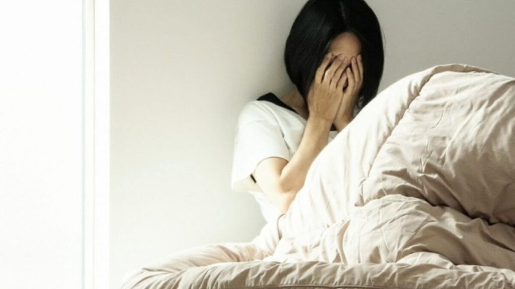 部屋で体調を崩している若い女性
