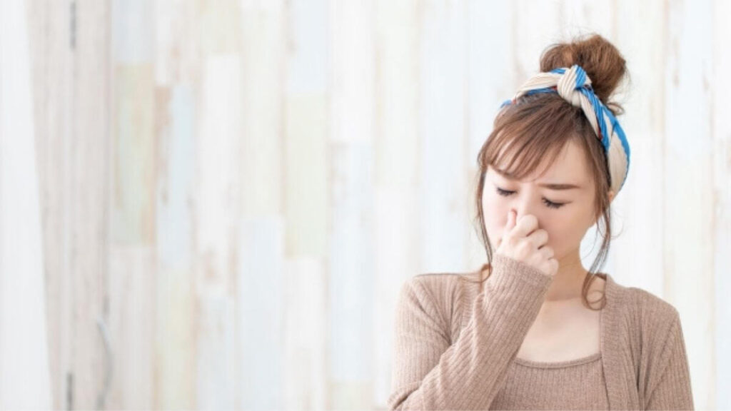 部屋の異臭から鼻を抑える若い女性