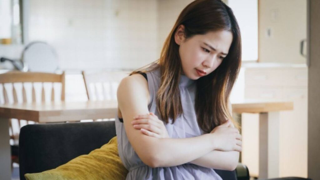 24時間換気が行われる部屋で寒そうにする女性