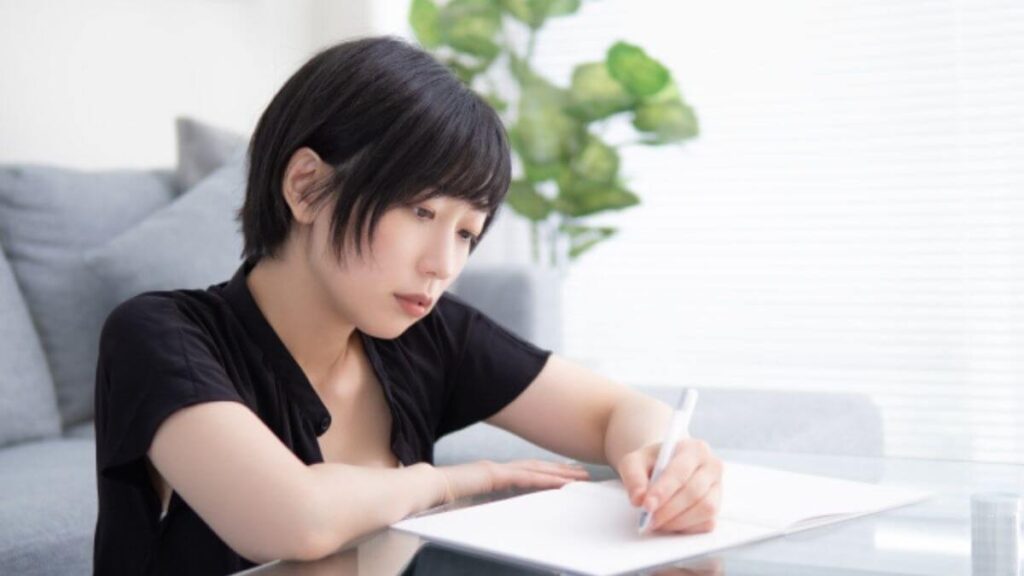 部屋で快適に勉強をする若い女性