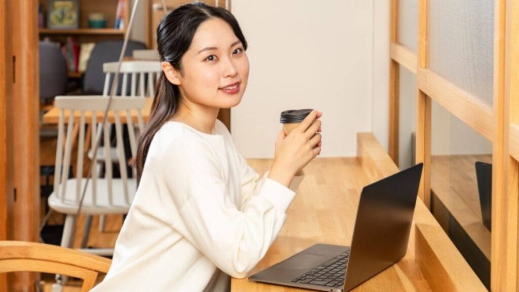 部屋でコーヒーを飲みながらリラックスする若い女性