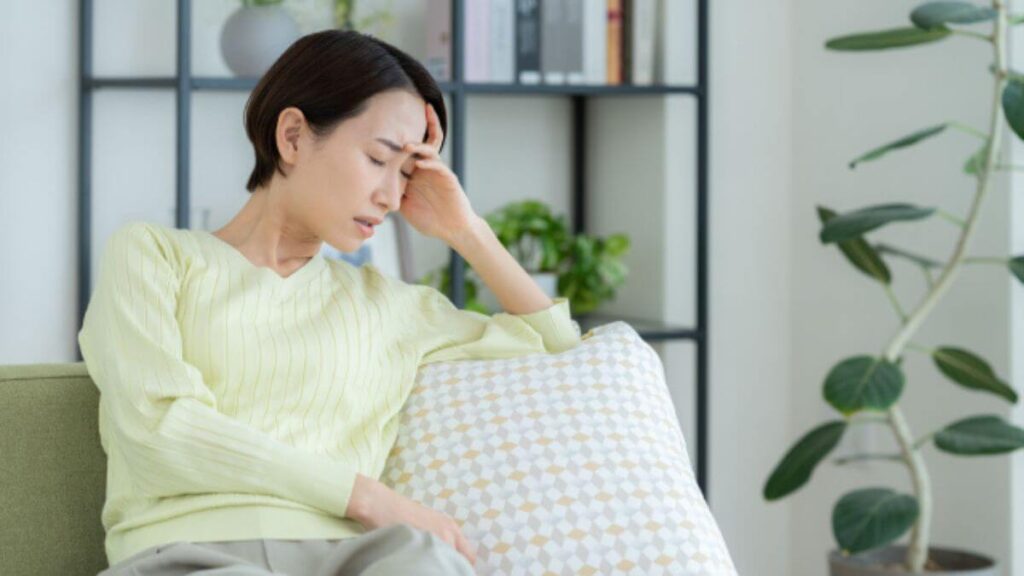 ソファーで頭を抱える女性