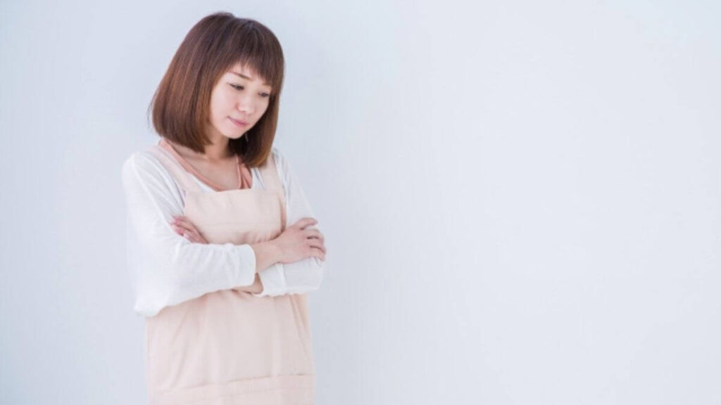 腕を組んで考える若い女性