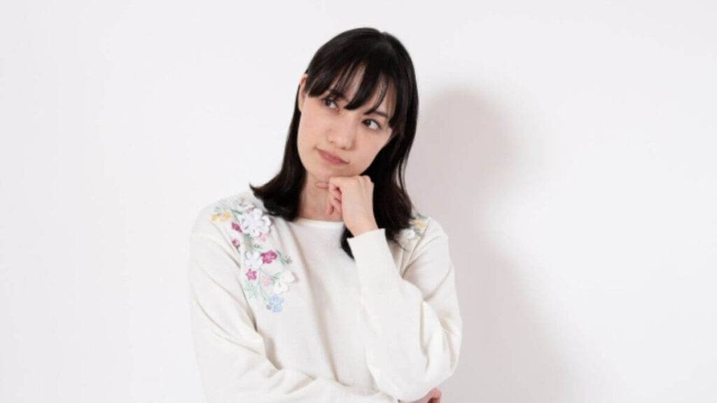 顎に手を置いて考える主婦