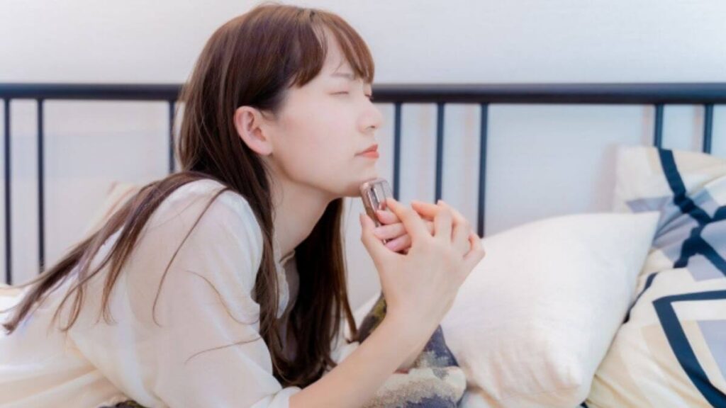 ベッドの上で悩む若い女性