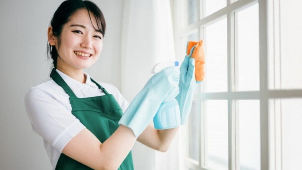 笑顔で掃除をするハウスクリーニング業者の女性