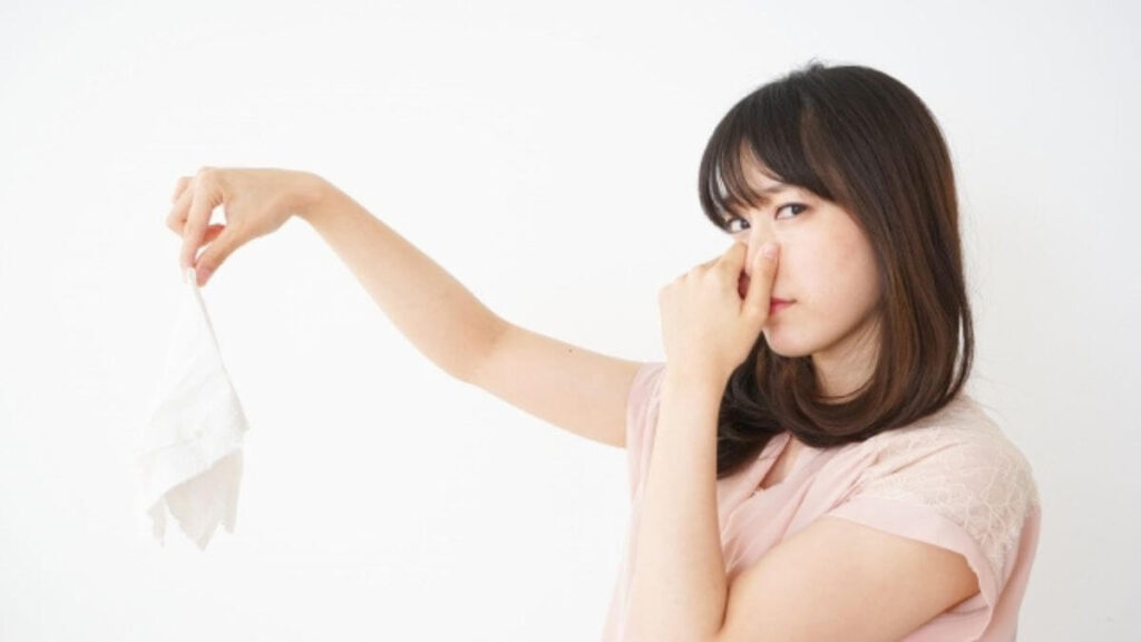 物の匂い嗅ぎ鼻を抑える女性