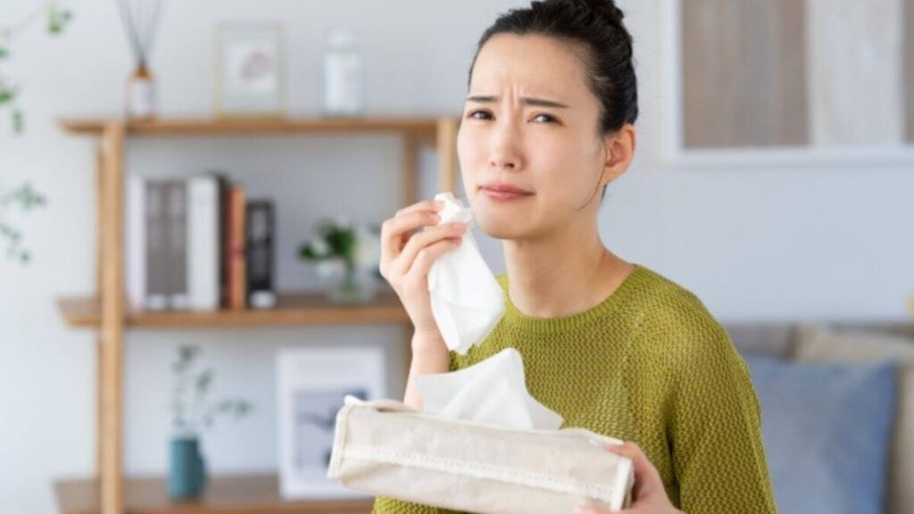 ティッシュを持ち涙を流す若い女性