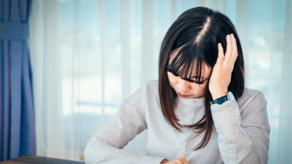 頭に手を置き悩む若い主婦