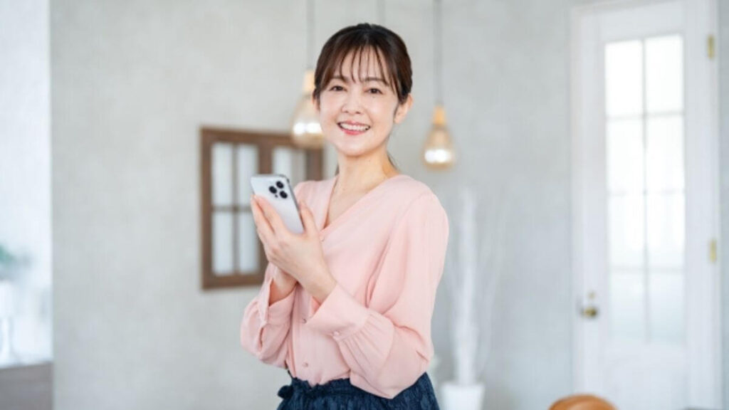 スマートフォンを持つ笑顔の主婦