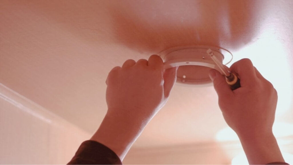 トイレの換気扇の修理をする業者の男性
