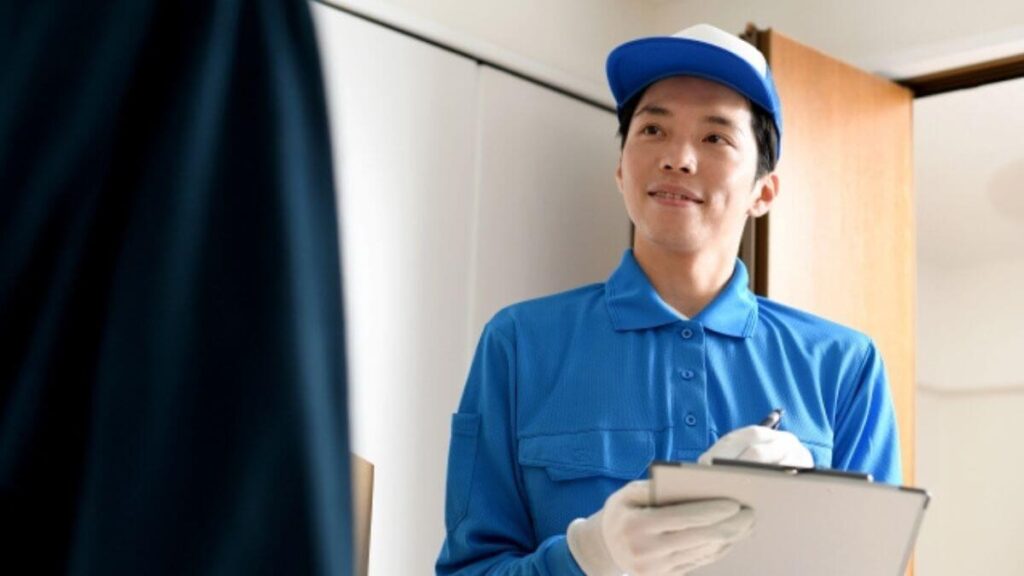 話を聞く作業着姿の若い男性