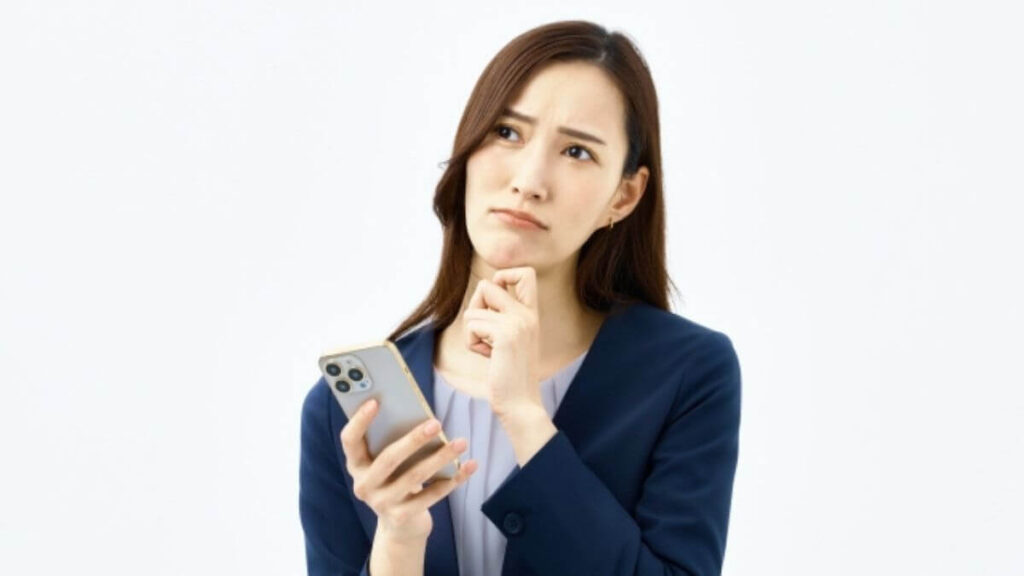 スマホを見ながら考える若い女性