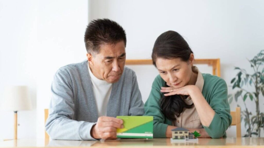 通帳を見て悩む老夫婦