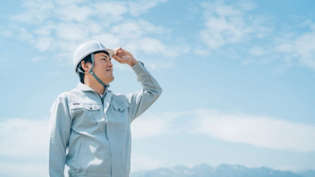 ヘルメットを被り立っている作業着姿の男性