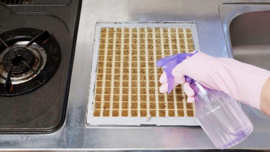 ゴム手袋をして換気扇掃除をしている様子