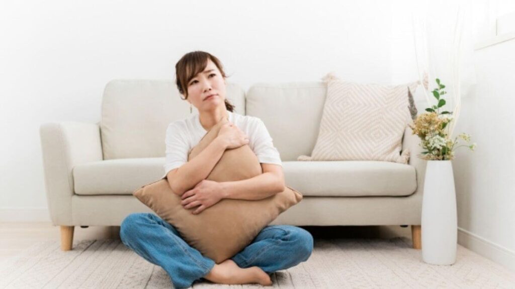 ソファー前で体調が悪そうな若い女性