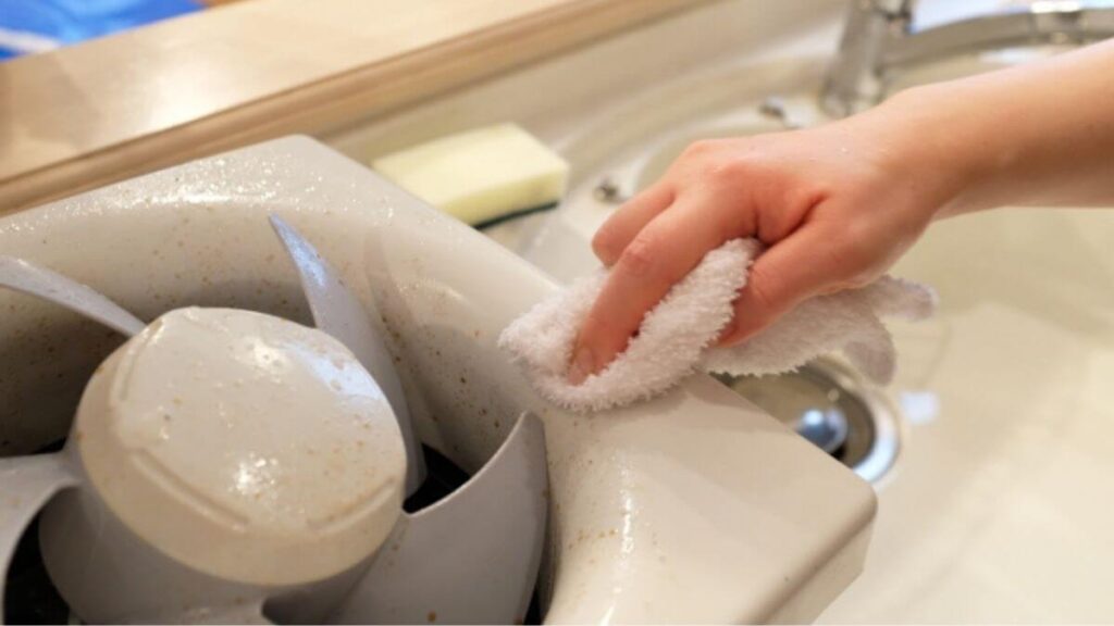 キッチンで換気扇掃除をする主婦