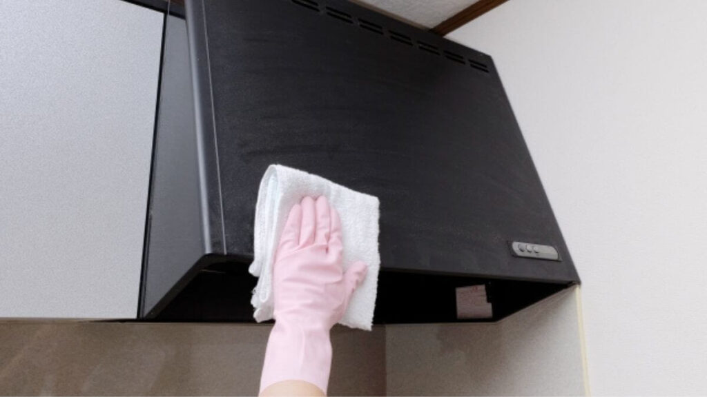 ふきんで換気扇を掃除する女性