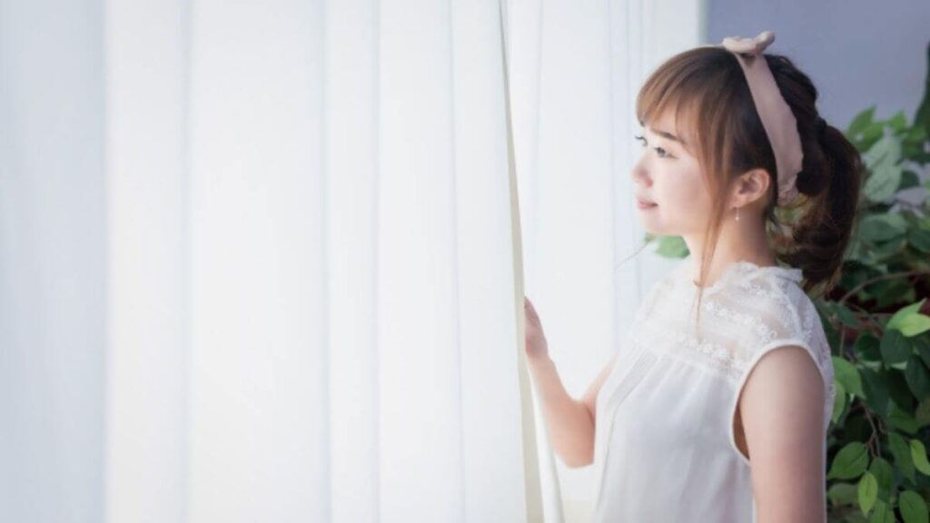 換気をして微笑む若い女性
