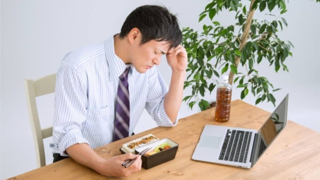 換気不足から頭痛を感じるサラリーマン