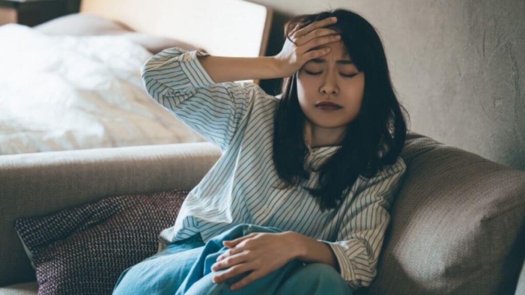 頭を抱え落ち込む若い女性