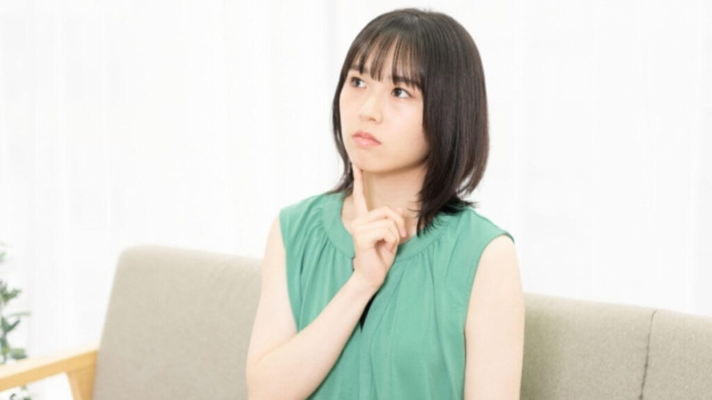室内で考え事をする若い女性