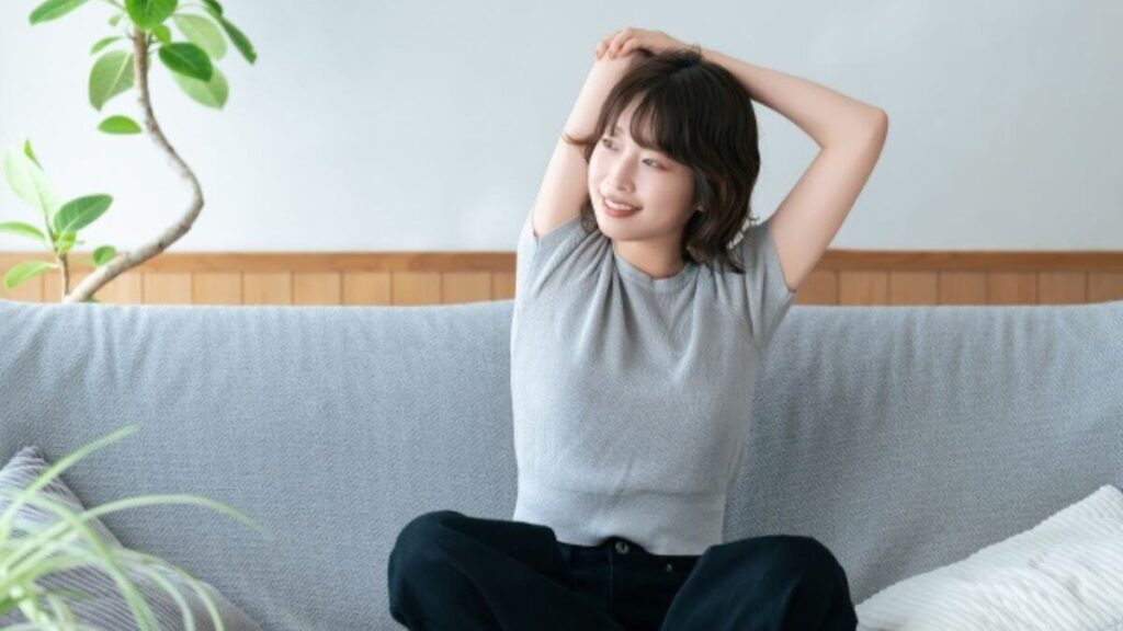 心配事がなくなりソファーでリラックスする若い女性