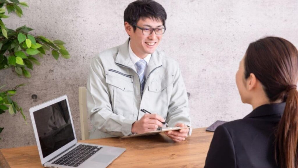 お客さんに説明をする作業着姿の業者の男性